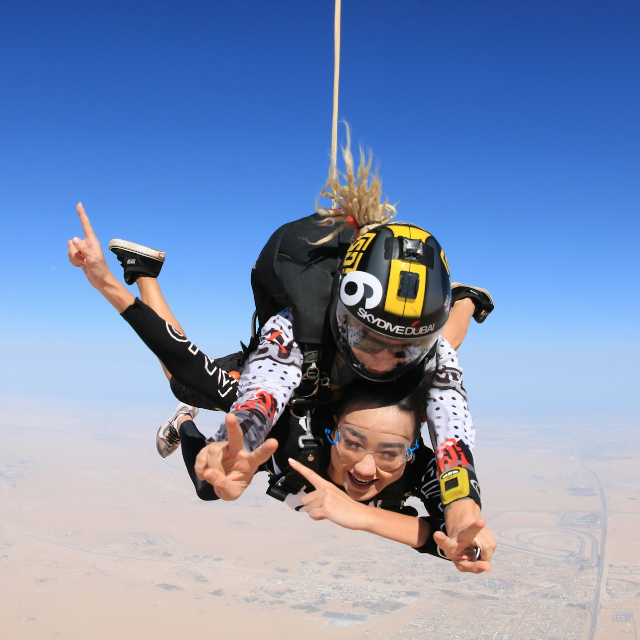 Experience the rush of tandem skydiving over the stunning desert landscape of Dubai capturing unforgettable moments in the sky with breathtaking views and professional video to share your adventure.